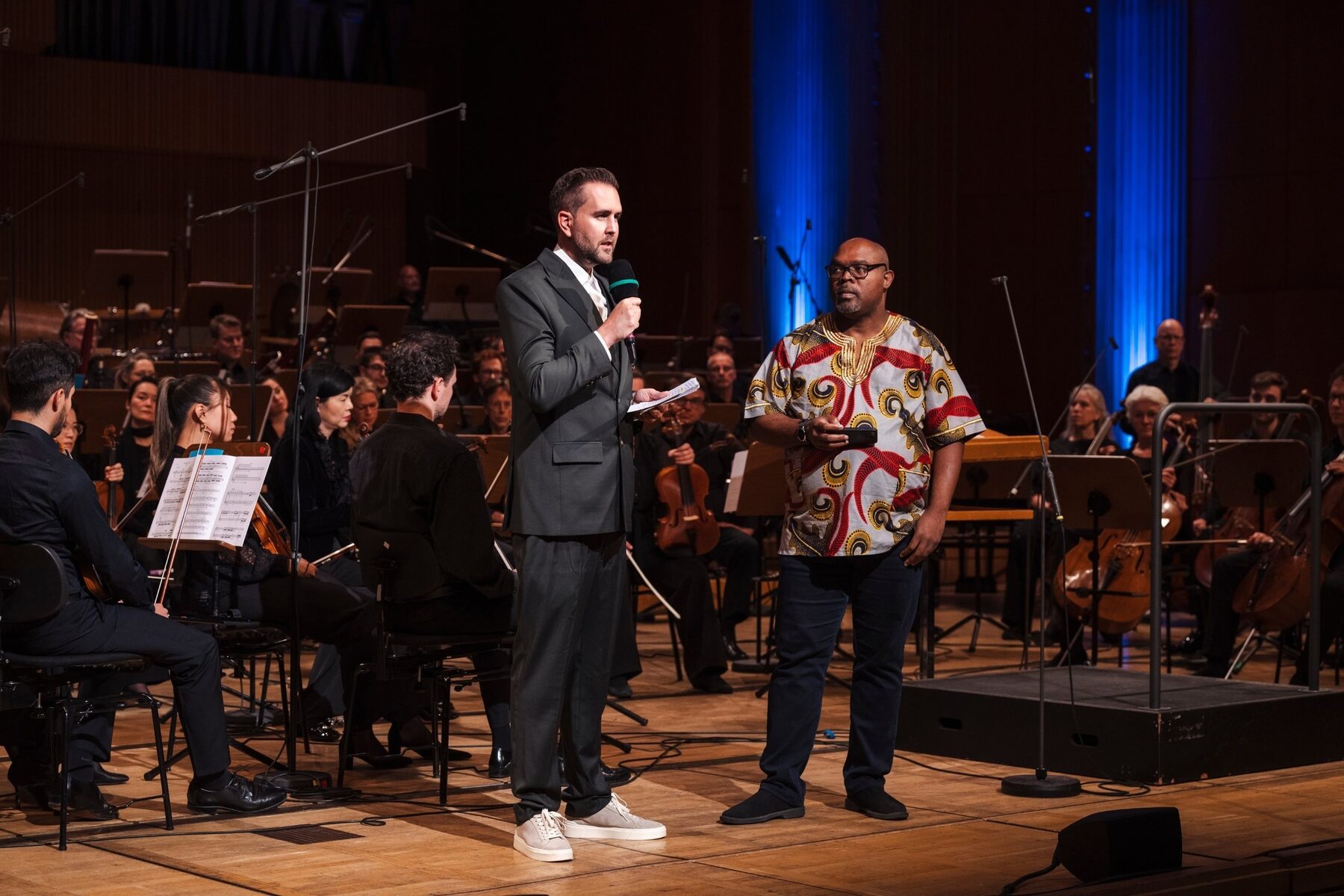 Philipp Quiring im Bühnengespräch mit einem Gast vor dem WDR Sinfonieorchester